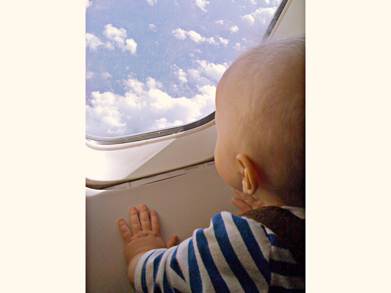 飛行機の外を眺める赤ちゃん