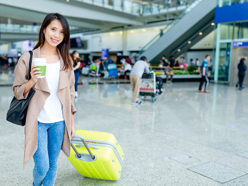 空港でコーヒーを持つ女性